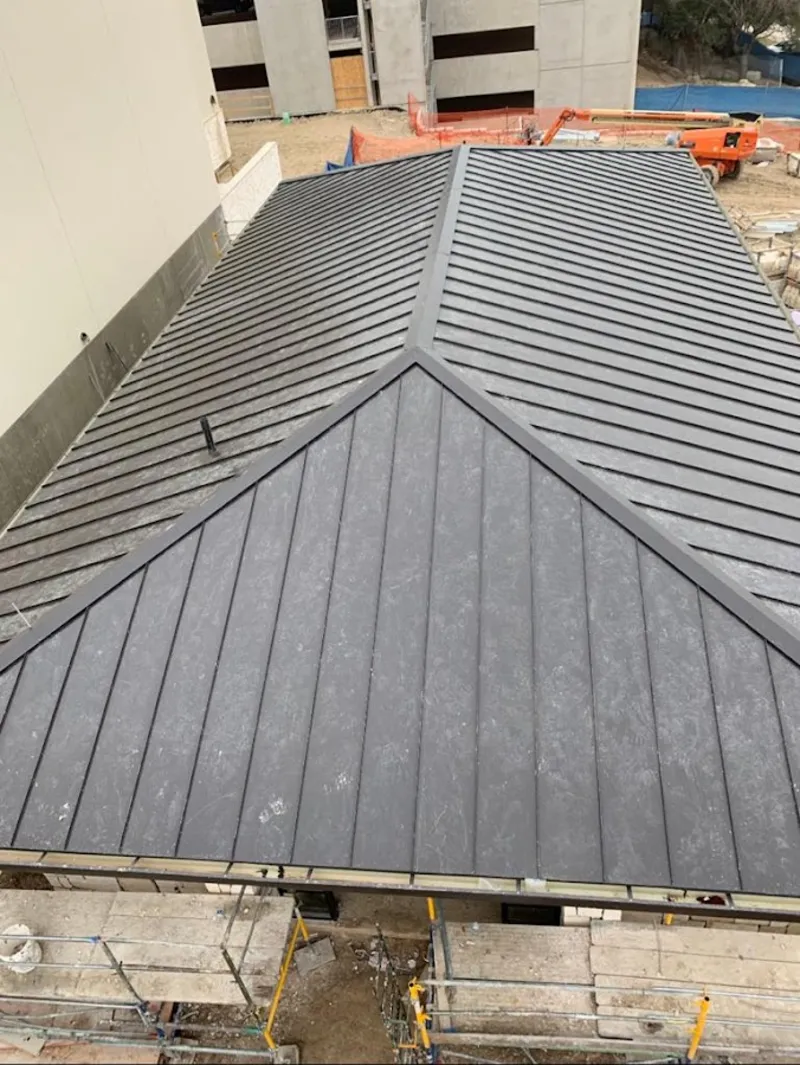 Commercial metal roof construction with crane equipment in Woodmoor